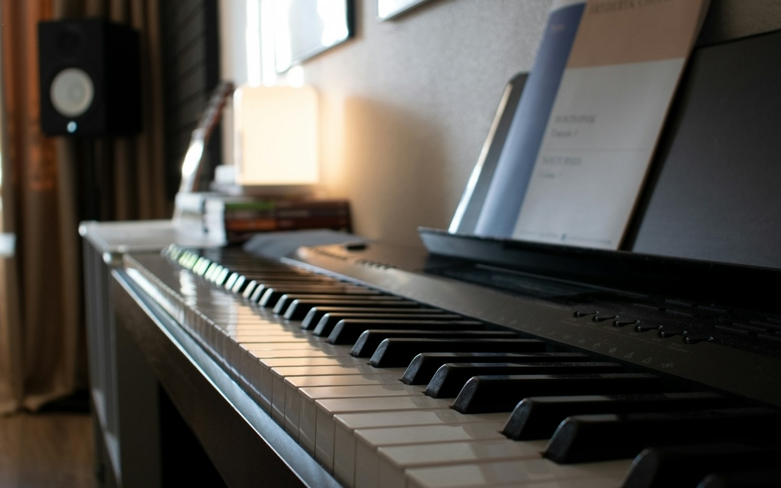 Audio frequency ranges from bass to treble Digital piano keyboard and sheet music in a warm studio